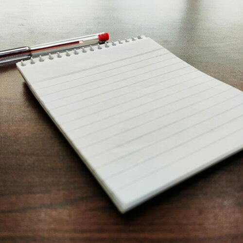 a notebook and a pen on a wooden table